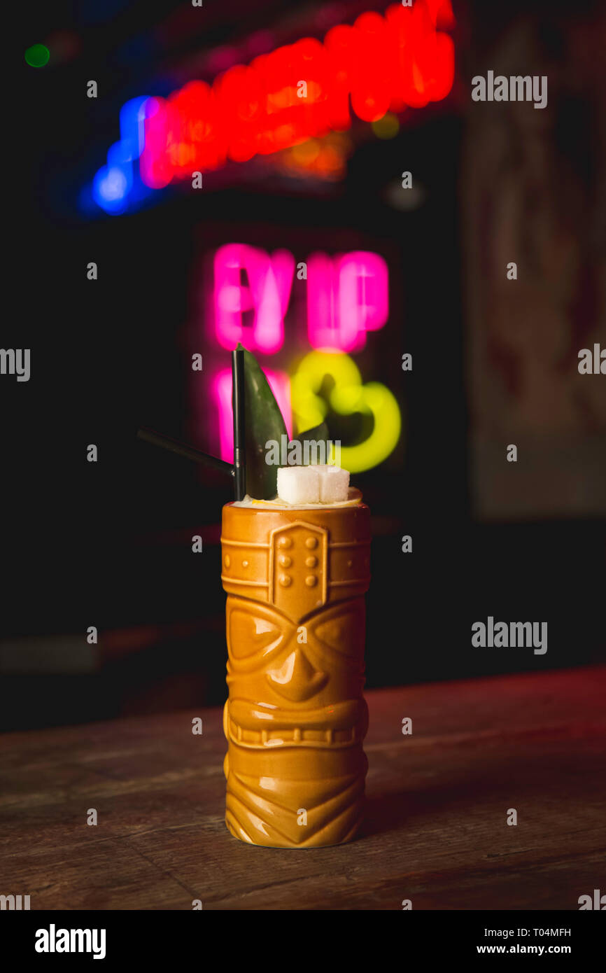 Totem pole cocktail on bar with neon signs in background Stock Photo