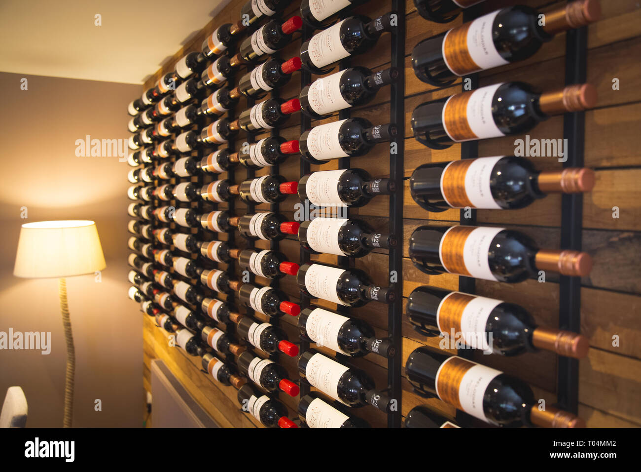 bottles of red wine on wall display in restaurant Stock Photo