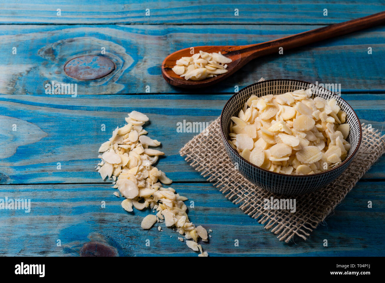 Laminated almond inside ceramic pot over blue pine wood Stock Photo - Alamy