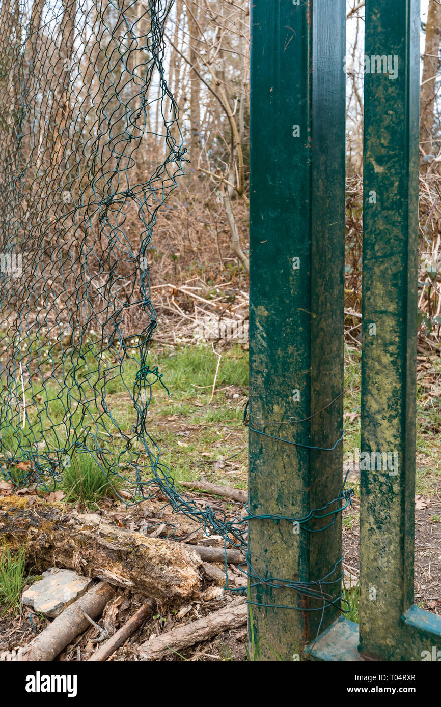 Security breach into wire mesh fence through big hole Stock Photo Alamy
