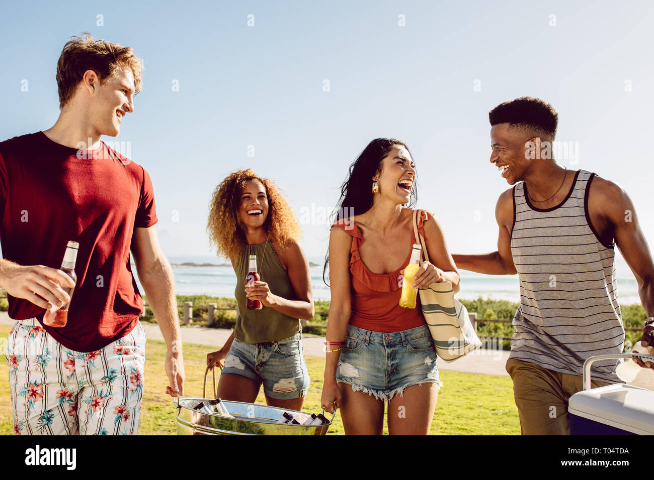 Friends summer beach party. Group of multi-ethnic men and woman together at the beach having fun. Stock Photo