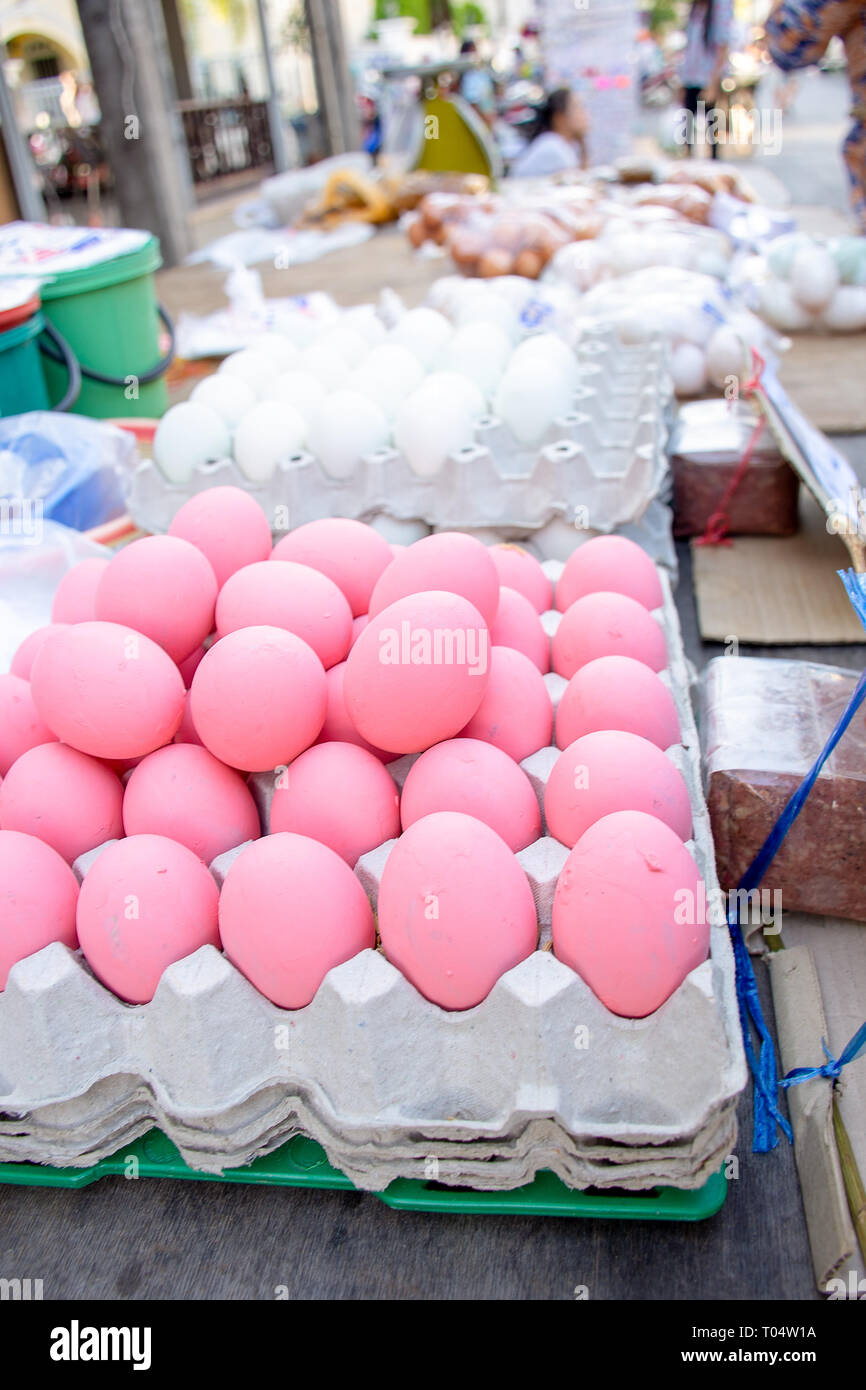 Chicken eggs painted pink for sale on market stall, Phuket, Thailand. Stock Photo