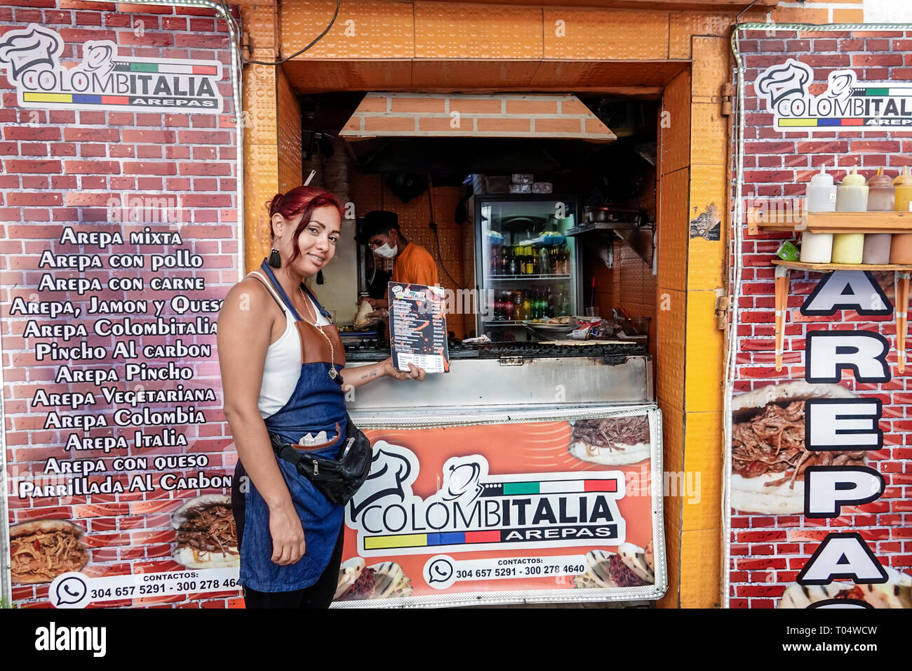 Cartagena Colombia,Center,centre,Getsemani,Hispanic resident residents,woman female women,offering menu,arepas stand stall vendor,menu,manager,COL1901 Stock Photo