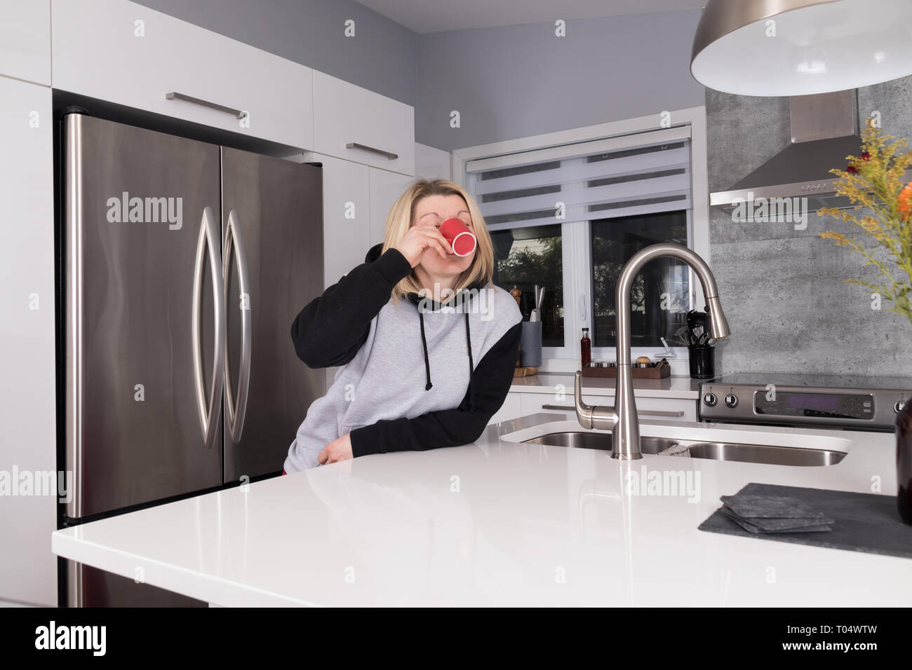beautiful blond woman having a coffee in the morning in her house Stock Photo