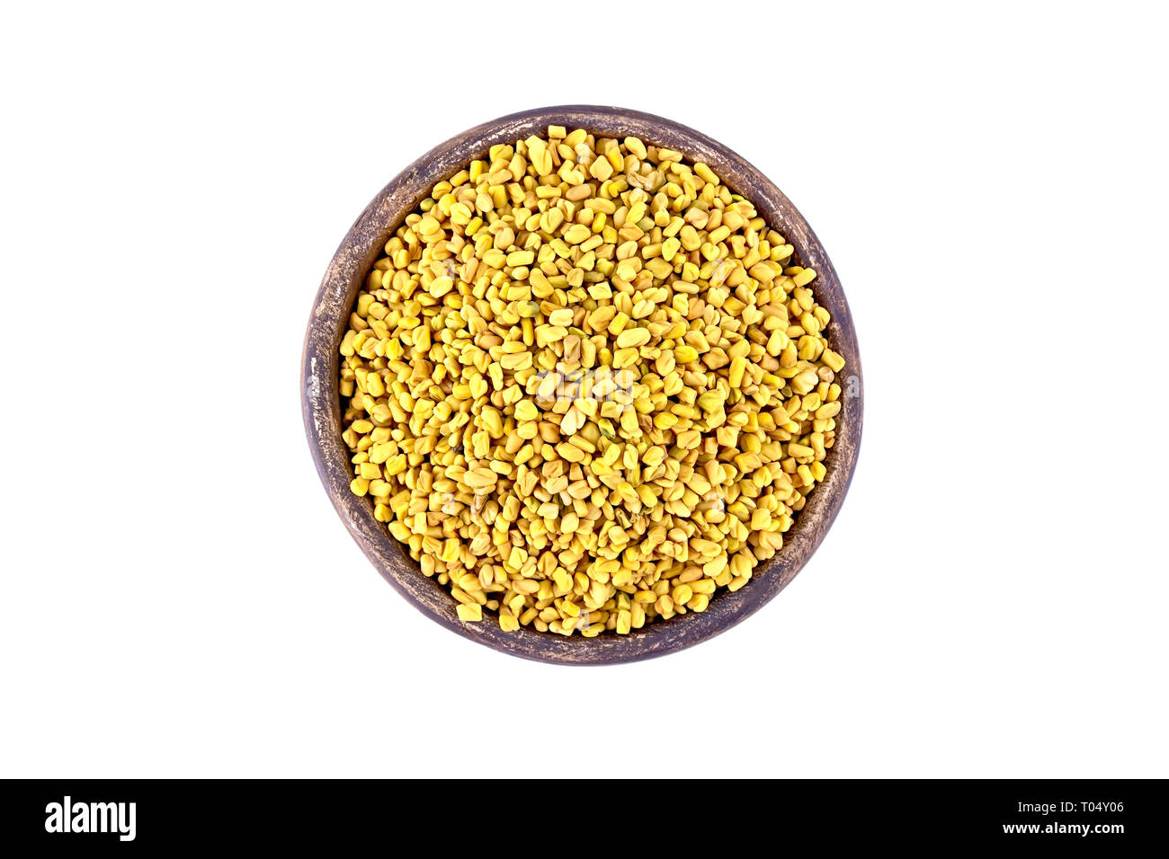 Fenugreek seeds in a clay bowl isolated on white background from above Stock Photo