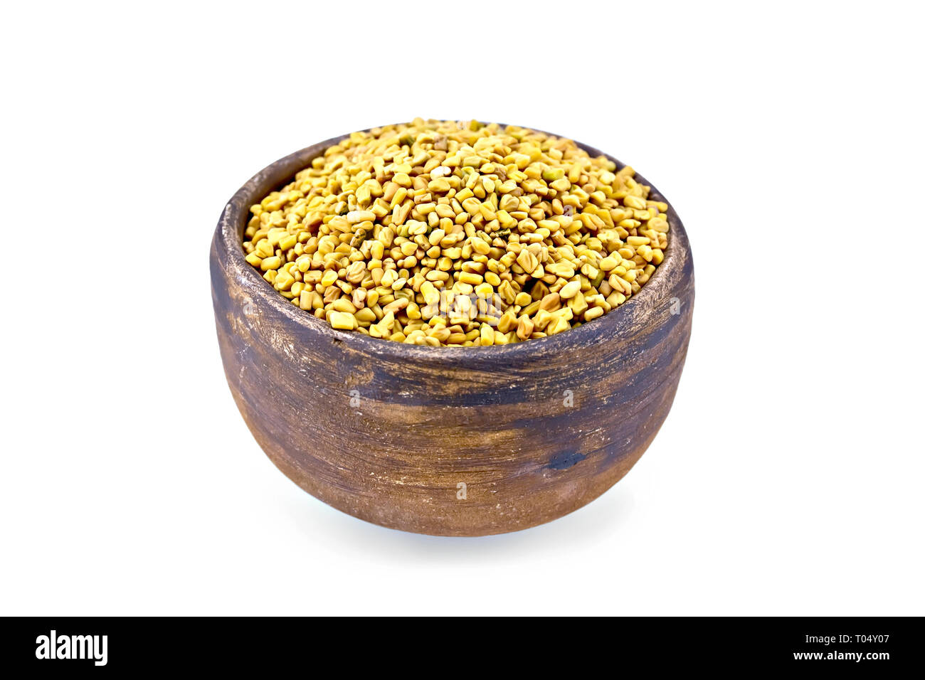 Fenugreek seeds in a clay bowl isolated on white background Stock Photo