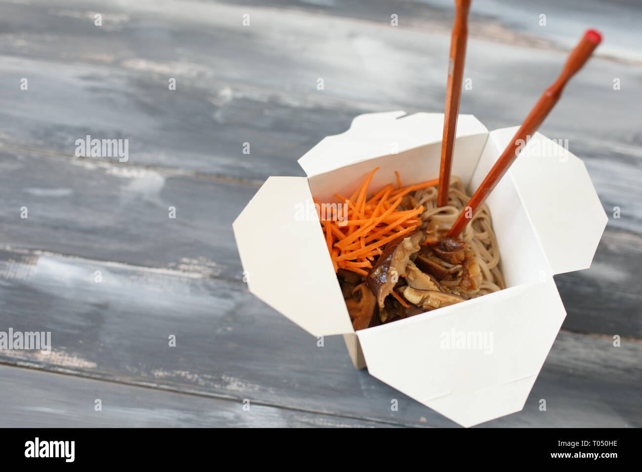 Shiitake mushrooms and soba noodles with carrot in a disposable wok box Stock Photo