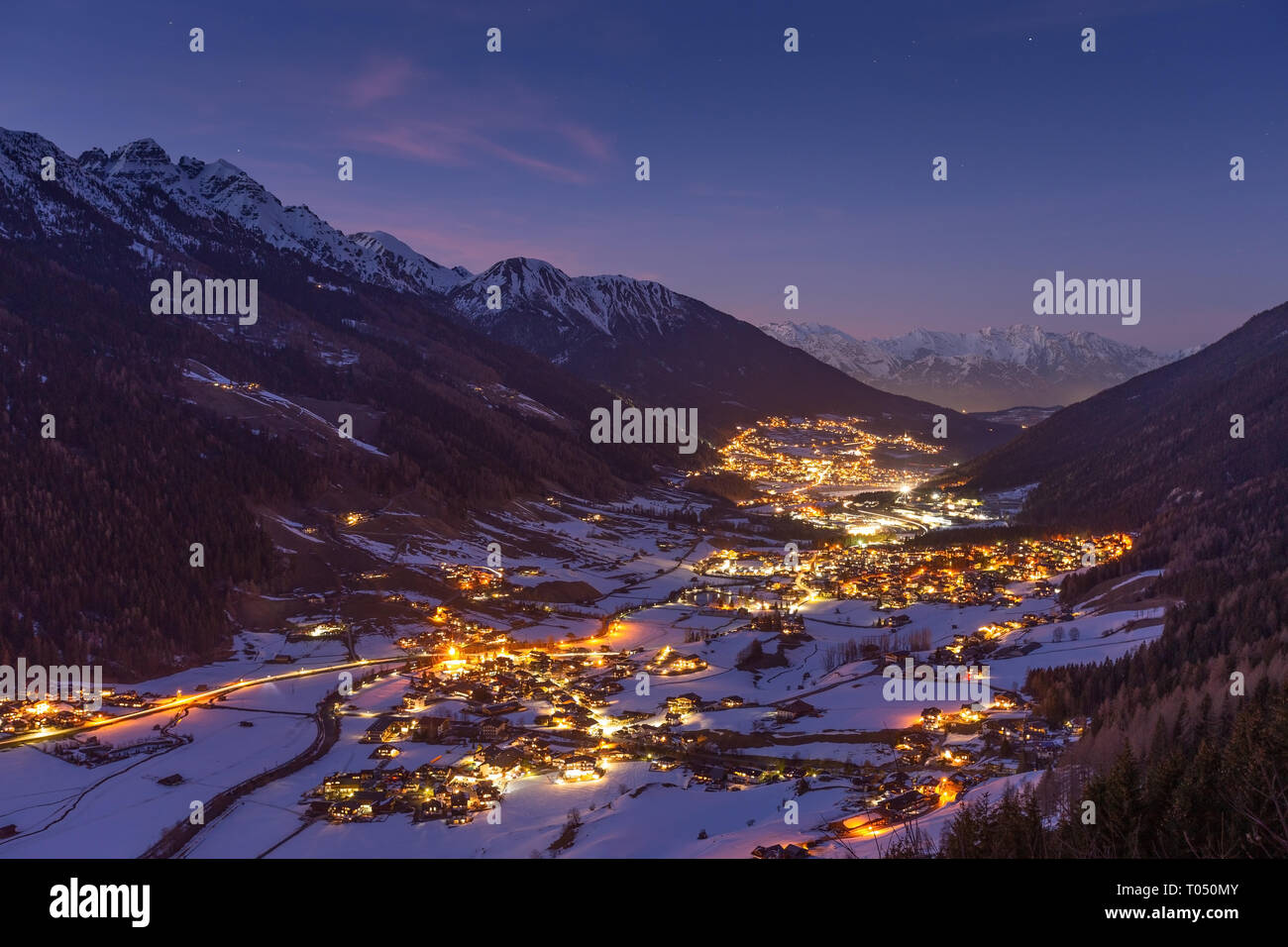 Stubai valley. Stubaital. Night landscape, winter season. Town lights.  Austrian Alps. Austria. Europe. Stock Photo