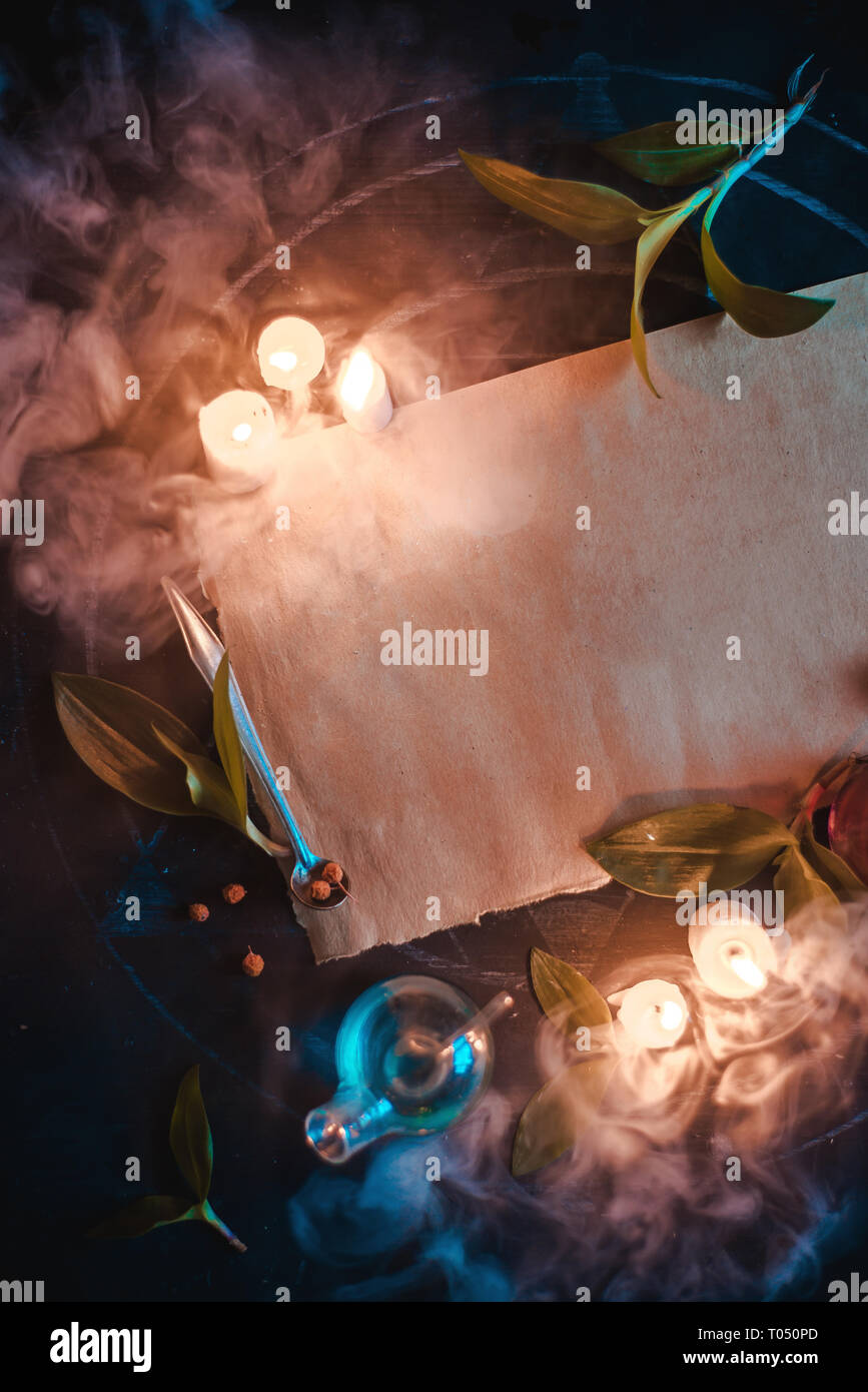 Magical scroll template with burning candles and place for text. Blank parchment with witch equipment and potions. Dark still life with copy space Stock Photo