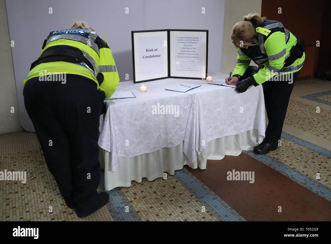 A couple of Gardais sign a book of condolence before a memorial service for the victims of the New Zealand Mosque attacks at St Marys Pro Cathederal in Dublin. Stock Photo