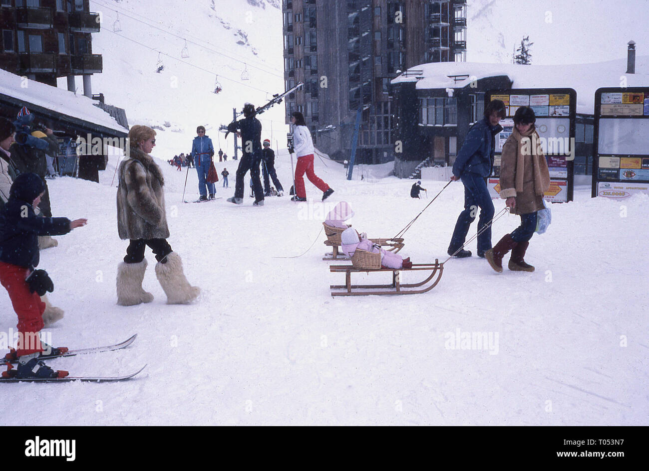 1960s, couple pulling their infant children sitting in baskets on sledges. Stock Photo