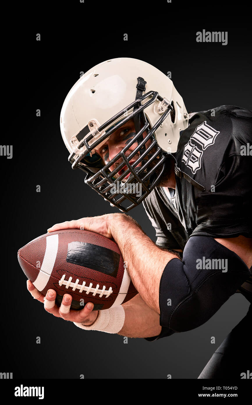 Portrait of American football player holding a ball with both his hands Stock Photo