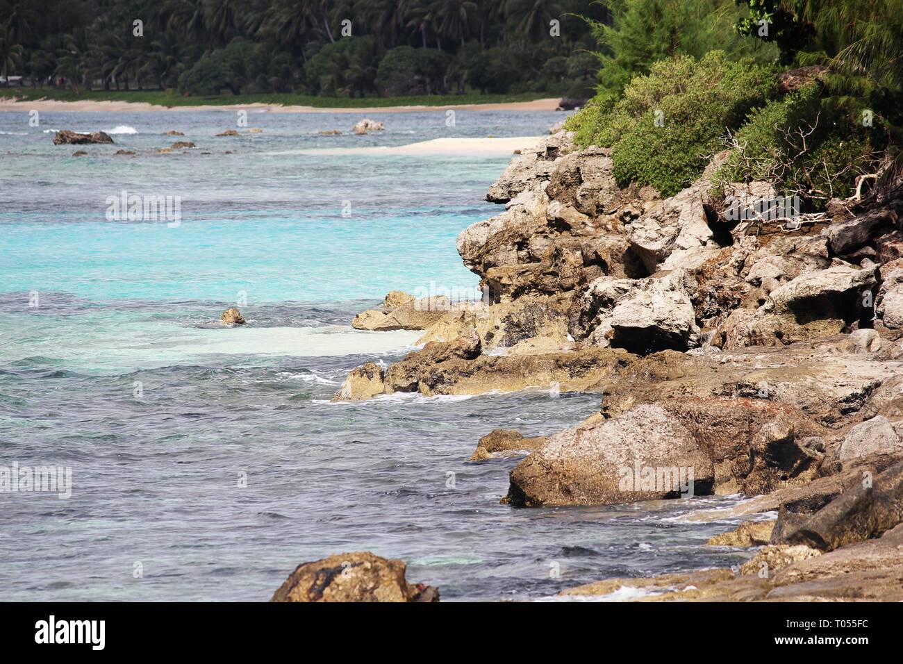 Different shades of blue waters with sharp rocky corals in a tropical beach Inarahan village on the southeastern coast of Guam Stock Photo