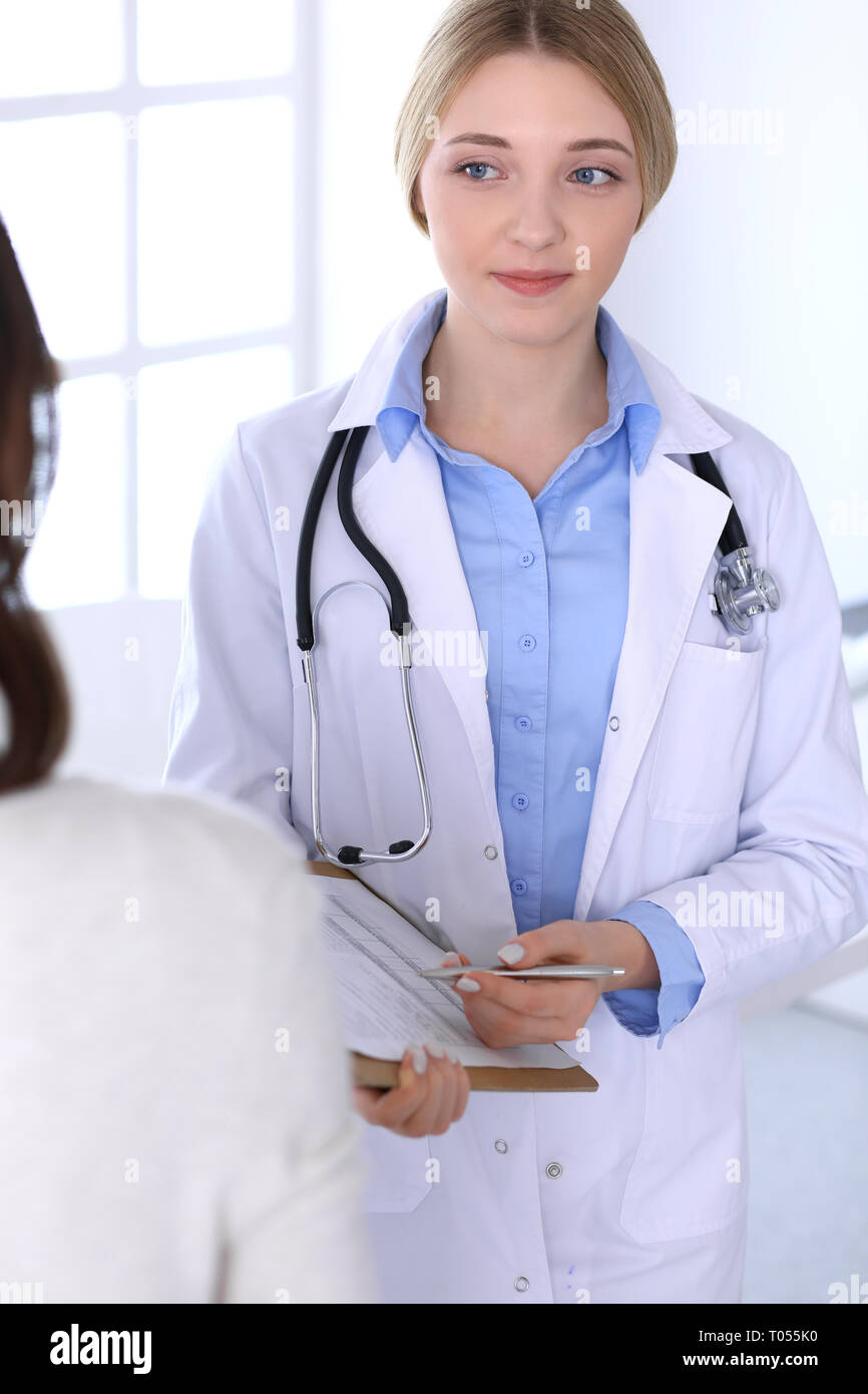 Young woman doctor and patient at medical examination at hospital office.  Blue color blouse of therapist looks good. Medicine and healthcare concept  Stock Photo - Alamy