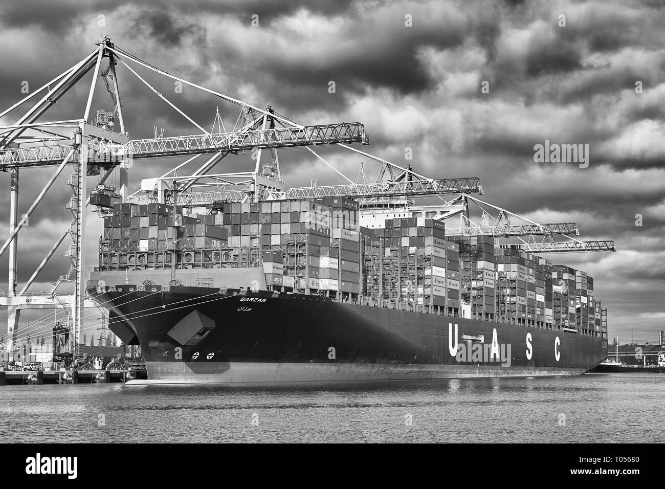 Moody Black & White Photo Of The Ultra-Large, 400 Metre, UASC Container Ship, BARZAN, Loading And Unloading In The Southampton Container Terminal Stock Photo