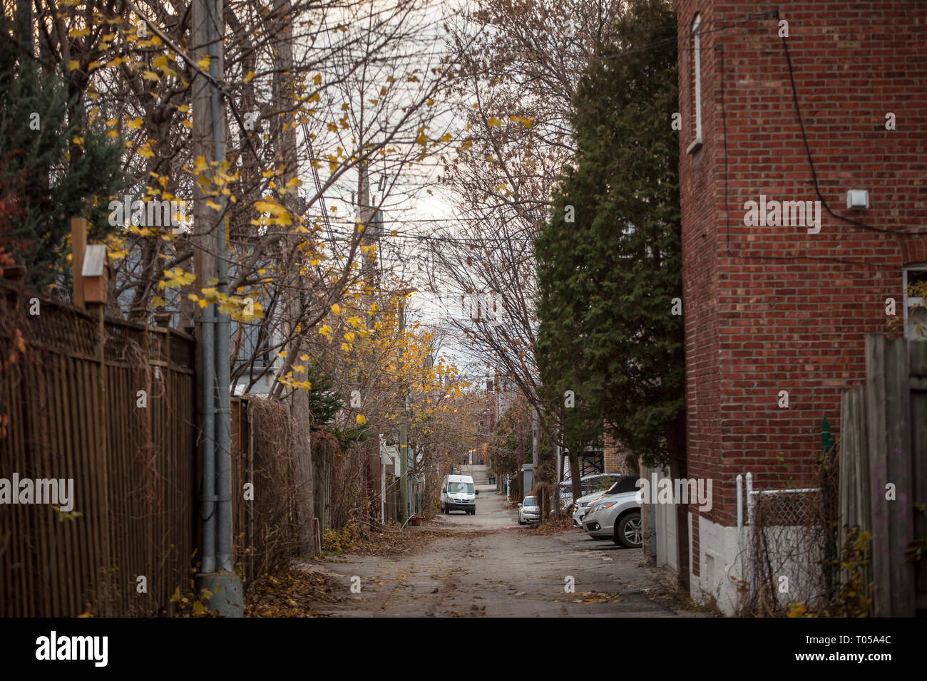MONTREAL, CANADA - NOVEMBER 8, 2018: Dilapidated typical north American residential street in autumn in Montreal, Quebec, during a rainy day, with car Stock Photo