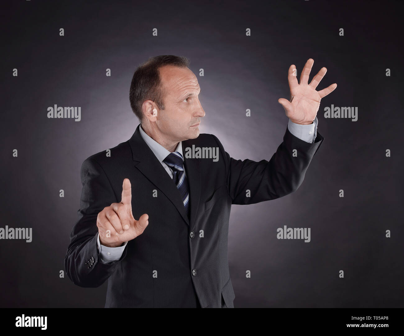 businessman pointing at a virtual point. photo on black background Stock Photo