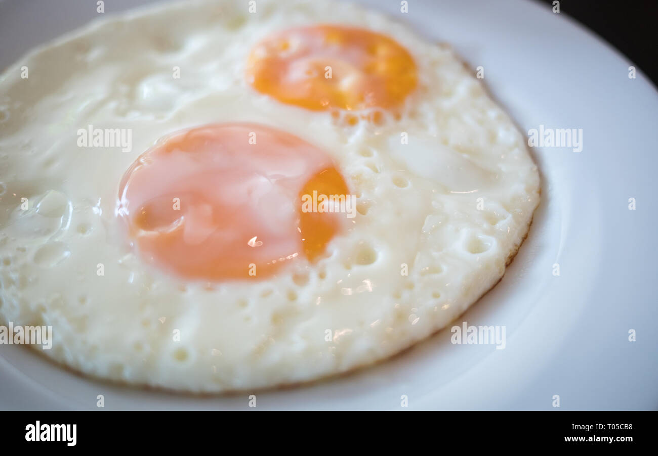 two fried egg on the white plate on breakfast table Stock Photo