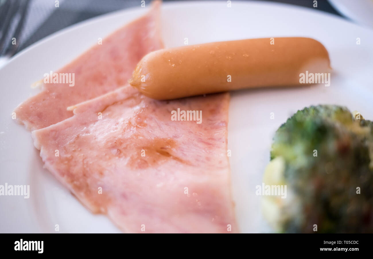 sausage with ham on the white plate on breakfast table Stock Photo