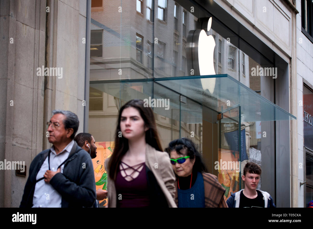 People walk past an Apple store on Walnut street in Center City