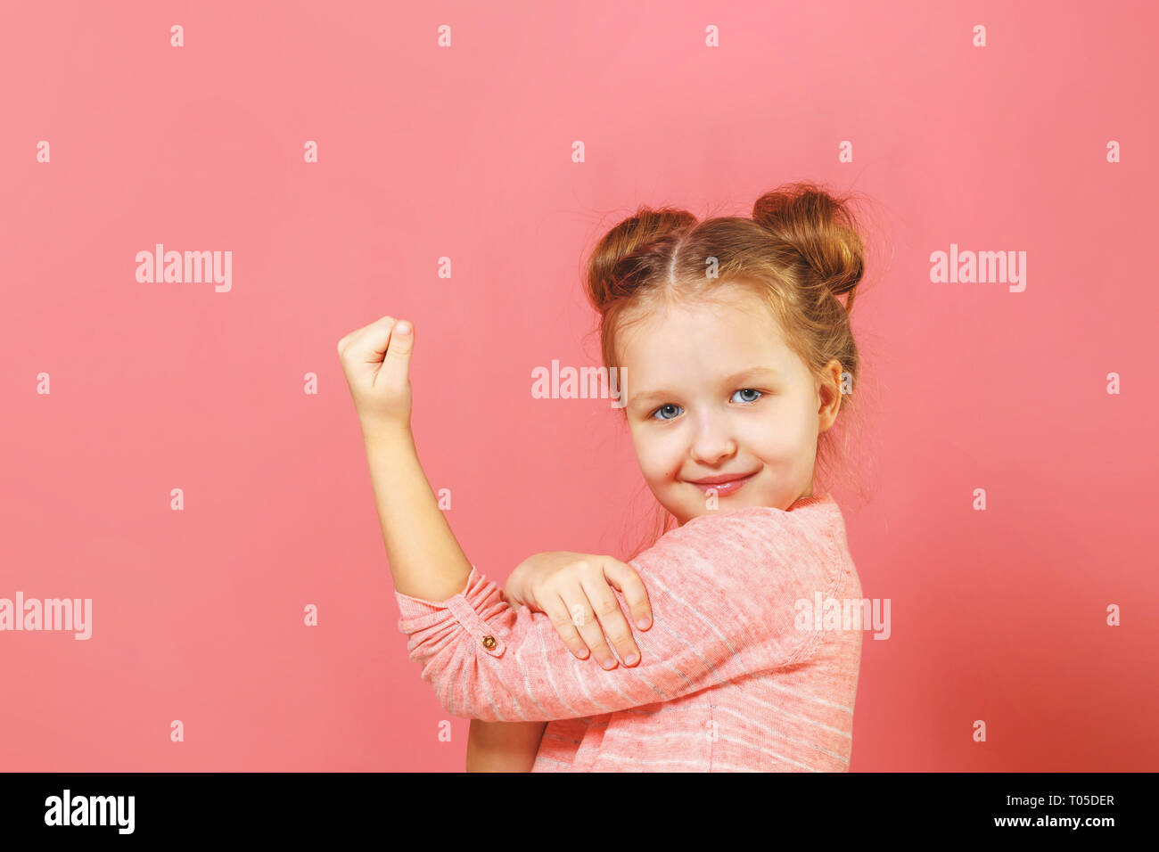 Closeup Portrait Of Cute Kid With Hair Buns Over Pink Background
