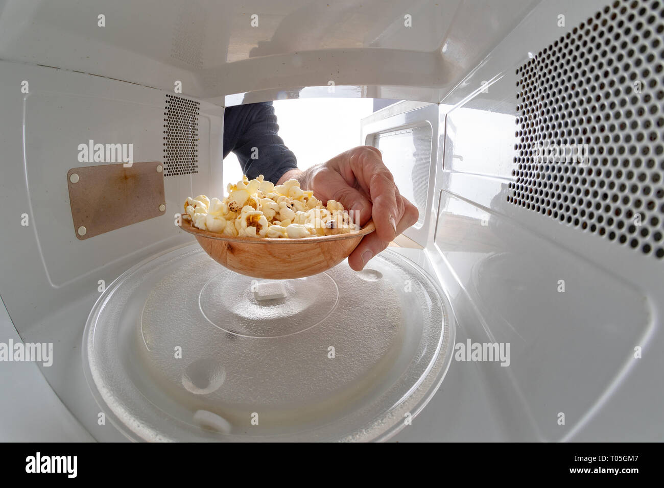 Microwave and bowl filled with popcorn. Device for heating dishes with