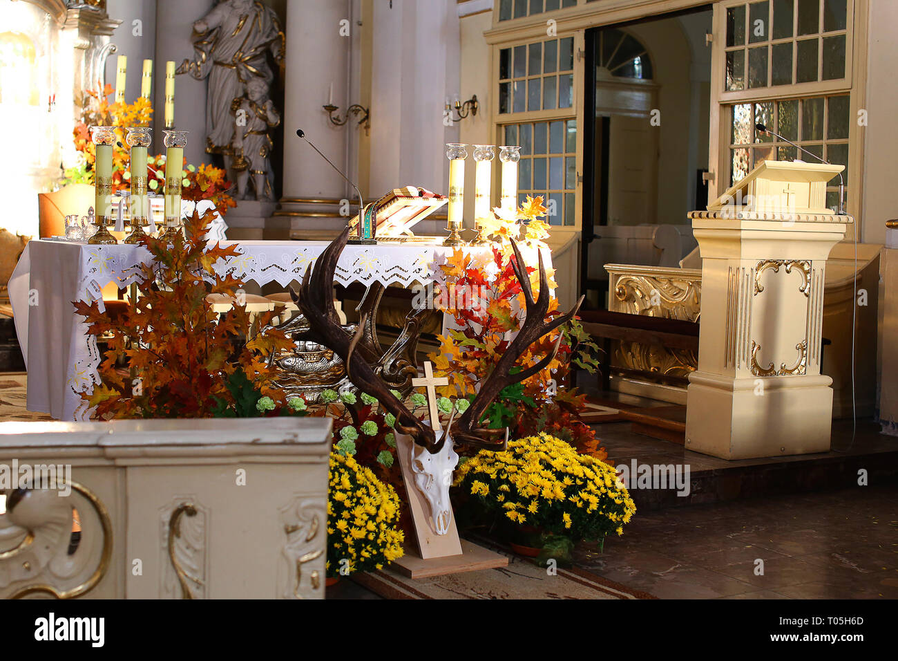 Local church altar is decorated with deer horns and seasonal flowers