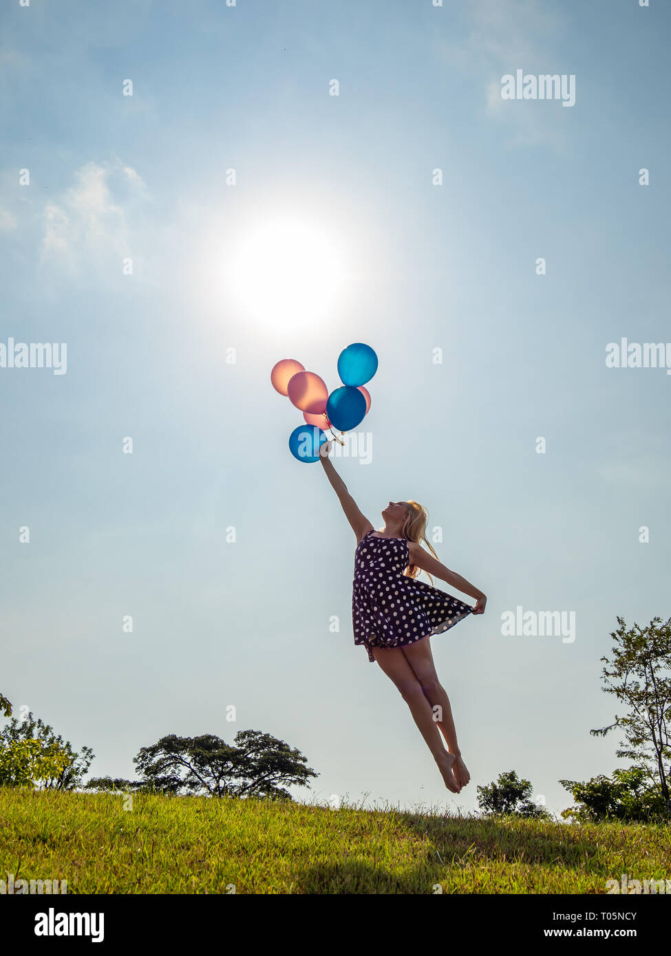 Female ballet dancer holding balloons flying away Stock Photo - Alamy