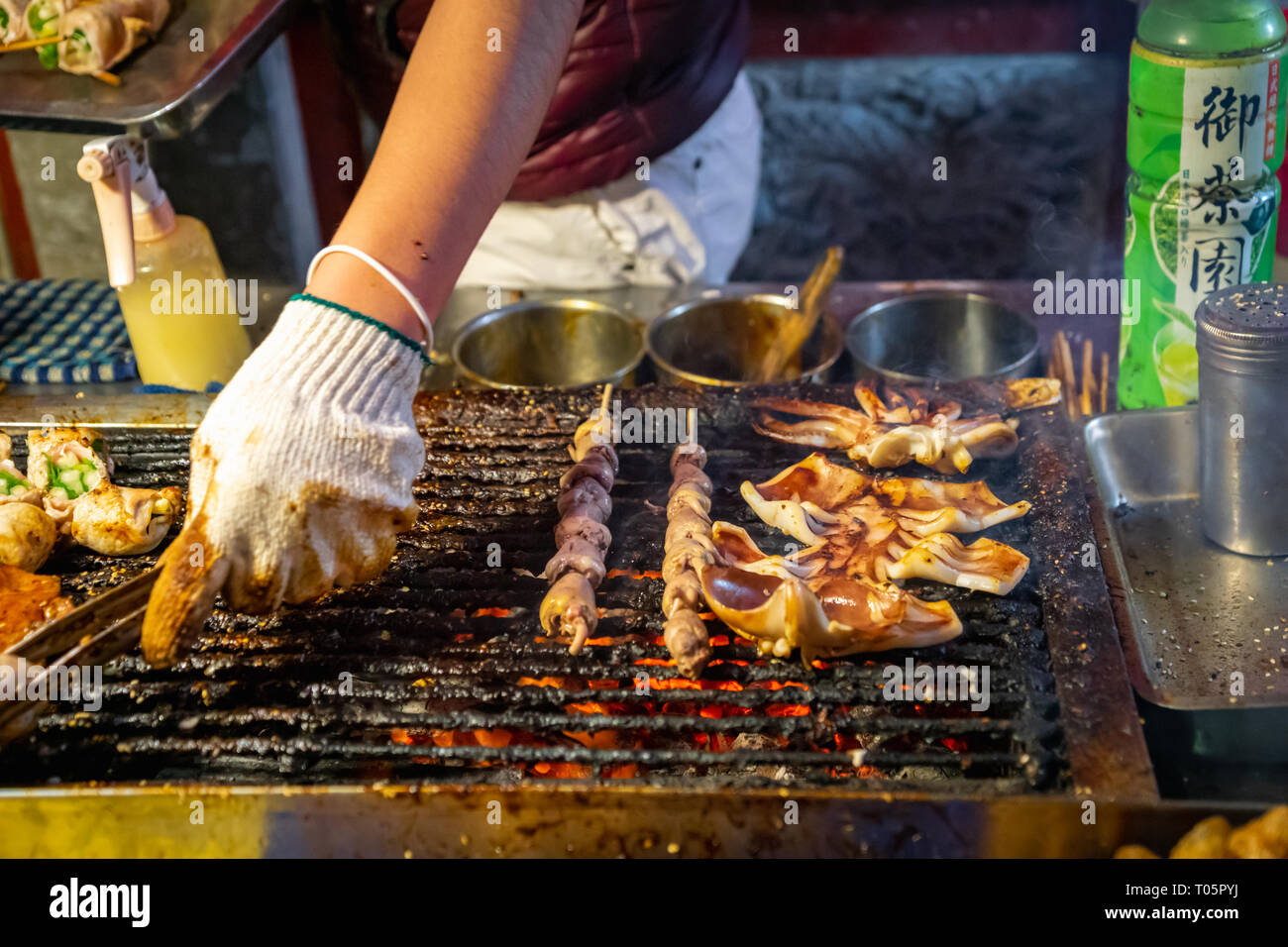 Grilled squid at night market street food stall Stock Photo - Alamy