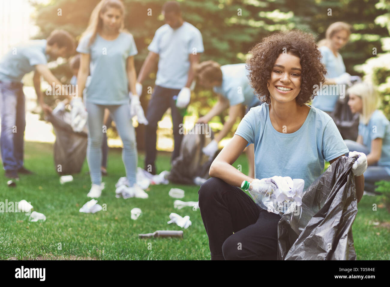 Group of volunteers with garbage bags cleaning park Stock Photo