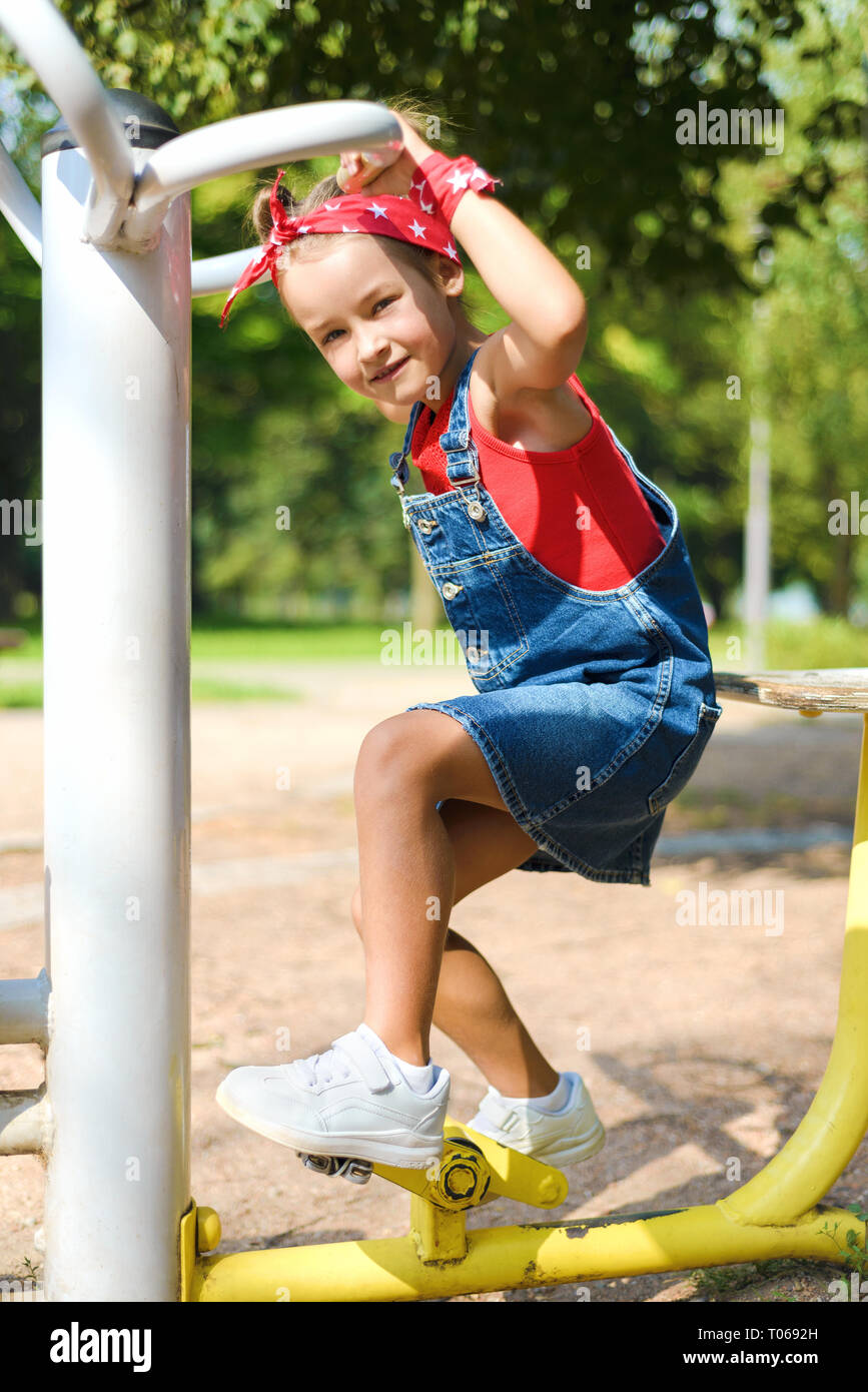 beautiful little girl in denim overalls and red kerchief white