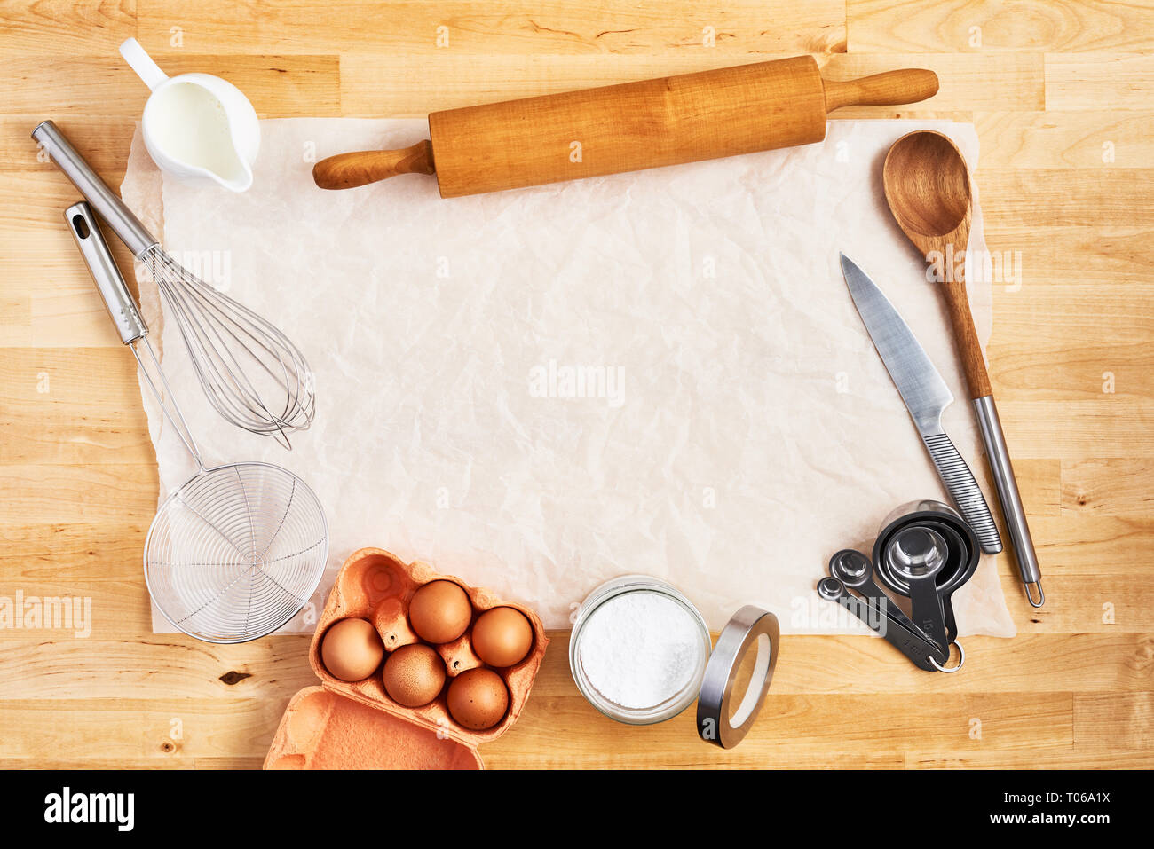 https://c8.alamy.com/comp/T06A1X/rolling-pin-food-ingredients-and-kitchen-utensils-on-crumpled-piece-of-white-parchment-or-baking-paper-on-wooden-table-baking-background-concept-to-T06A1X.jpg