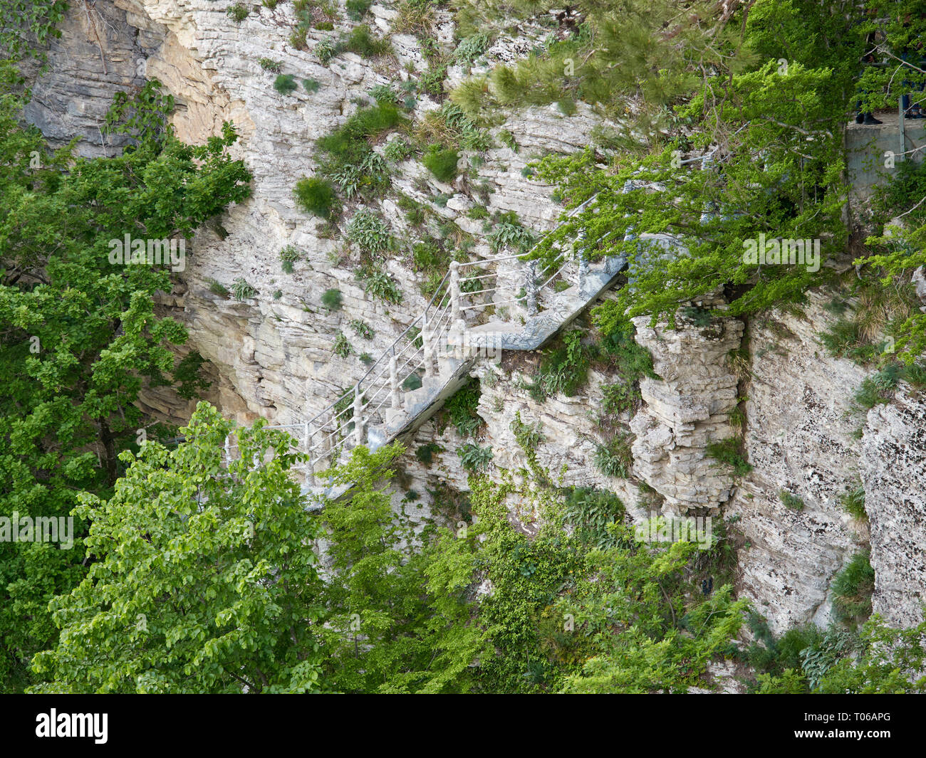 Ladder for descent on a cliff of limestone. Dangerous descent. Steep stairs. Stock Photo