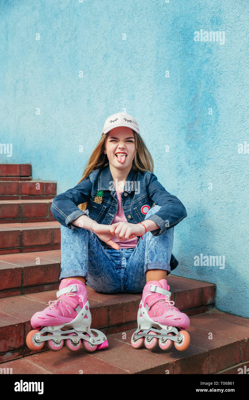 Teenager girl on roller skates sitting on step in city Stock Photo - Alamy