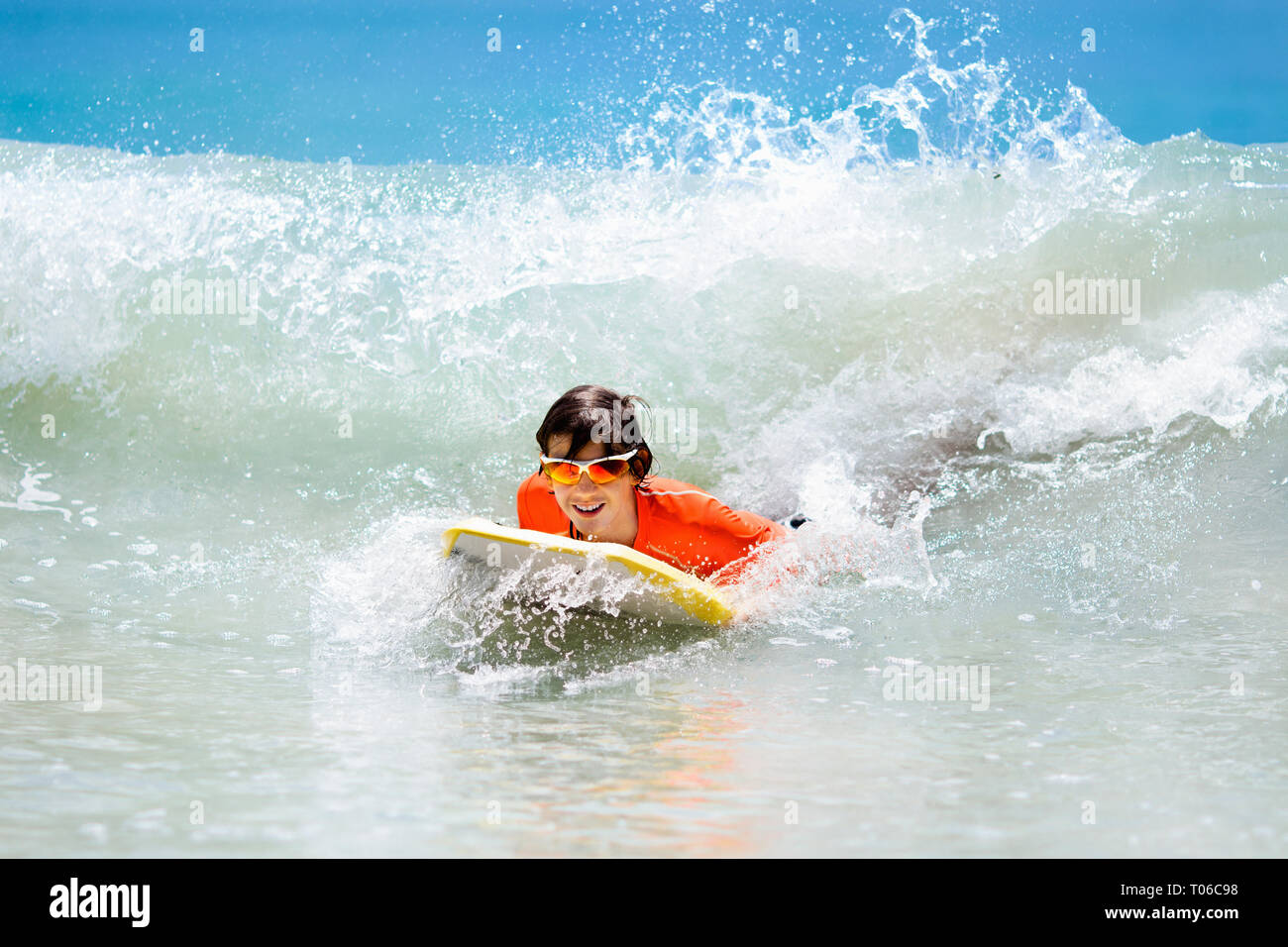 Teenager boy surfing on tropical beach in Asia. Child on surf board on ...