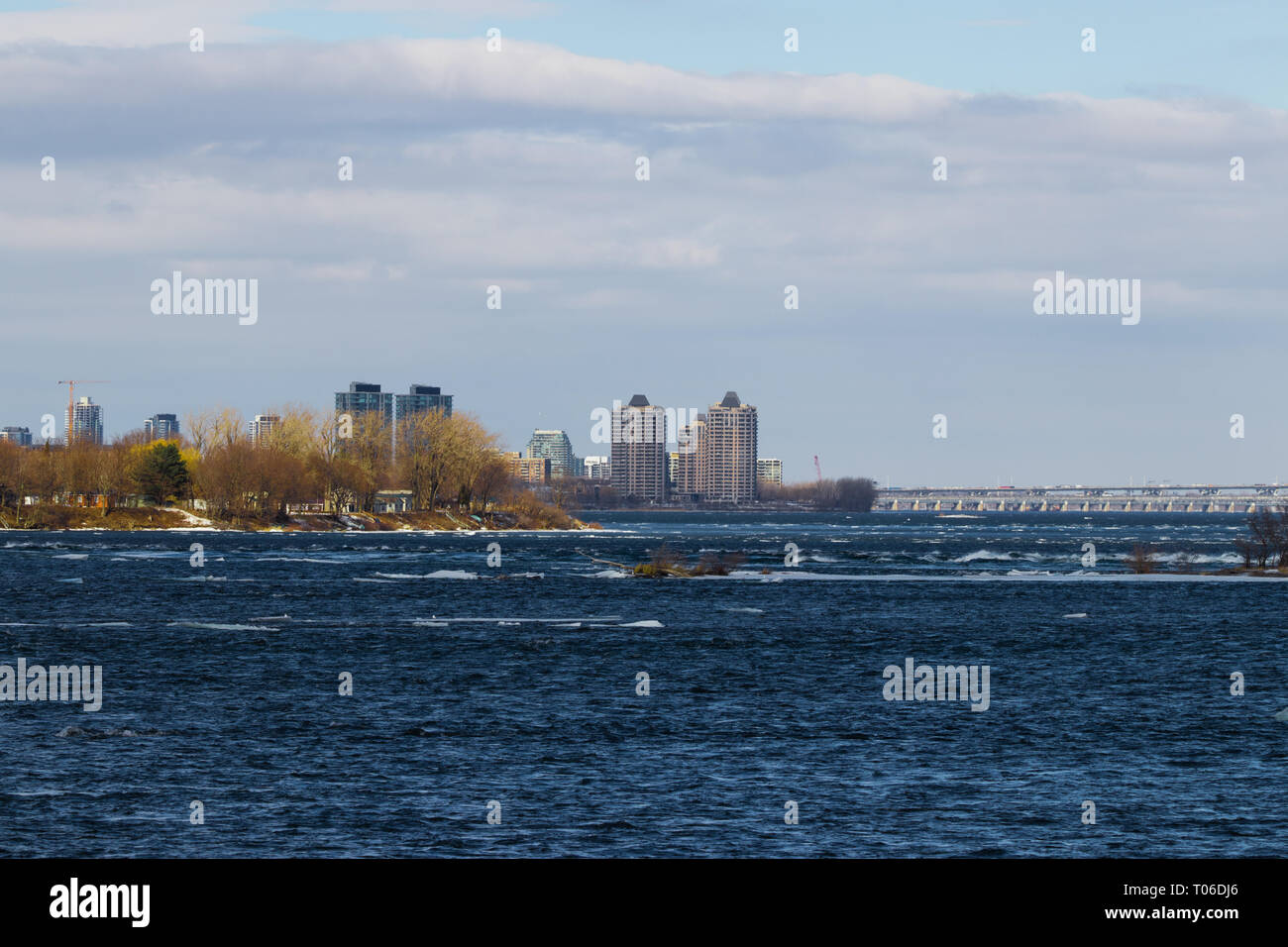 Landscape by the river at the beggining of Spring. View of Ile des Soeurs and Champlain Bridge, Montreal, Quebec, Canada Stock Photo