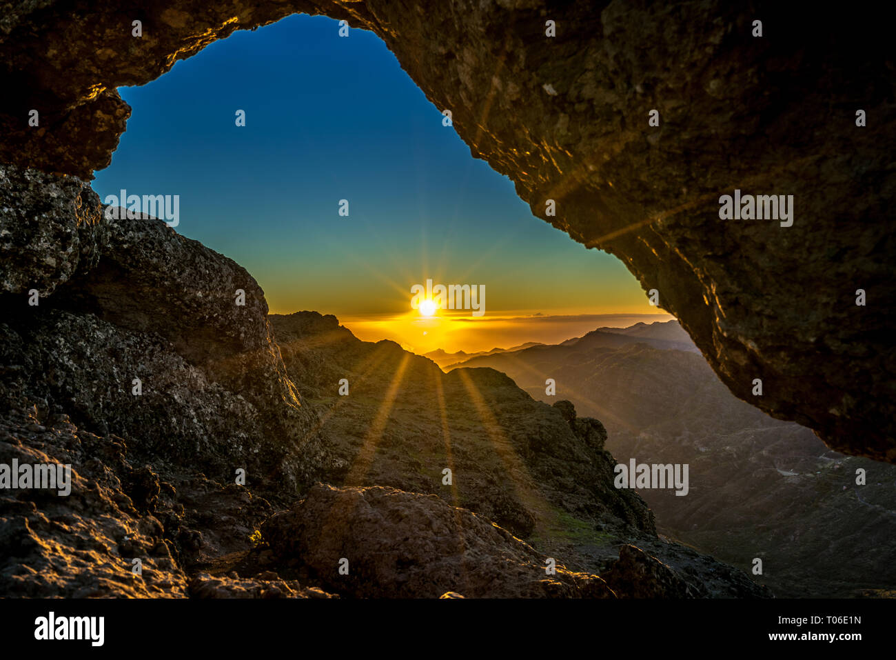 Sunset and mountin landscape view from eroded stone arch know as Ventana del nublo or La Agujereada. One of the hisgest places in Gran Canaria Island. Stock Photo