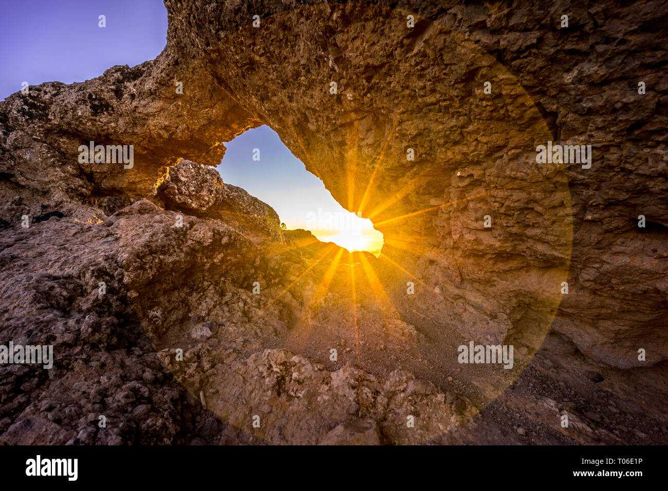 Sunset and mountin landscape view from eroded stone arch know as Ventana del nublo or La Agujereada. One of the hisgest places in Gran Canaria Island. Stock Photo