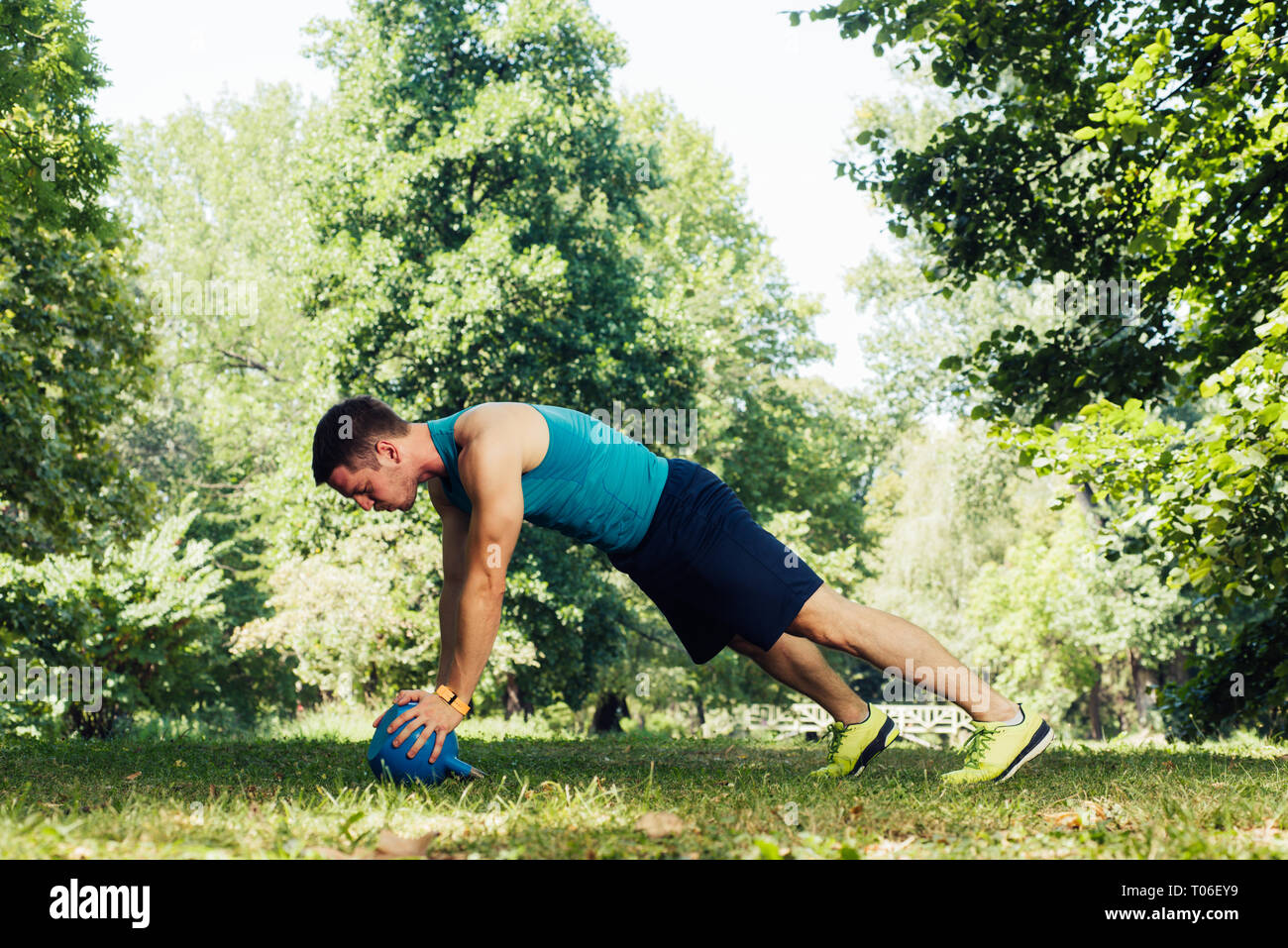 Healthy man doing push up holding kettlebell at the park Stock Photo ...