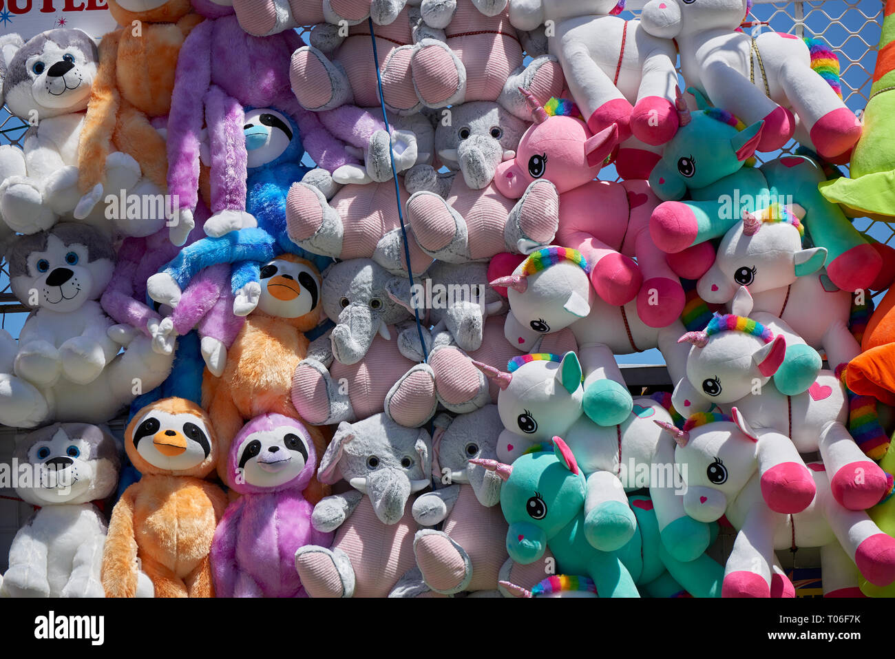 Stuffed animal toys at a fair as prizes hanging on mass on a wall Stock  Photo - Alamy