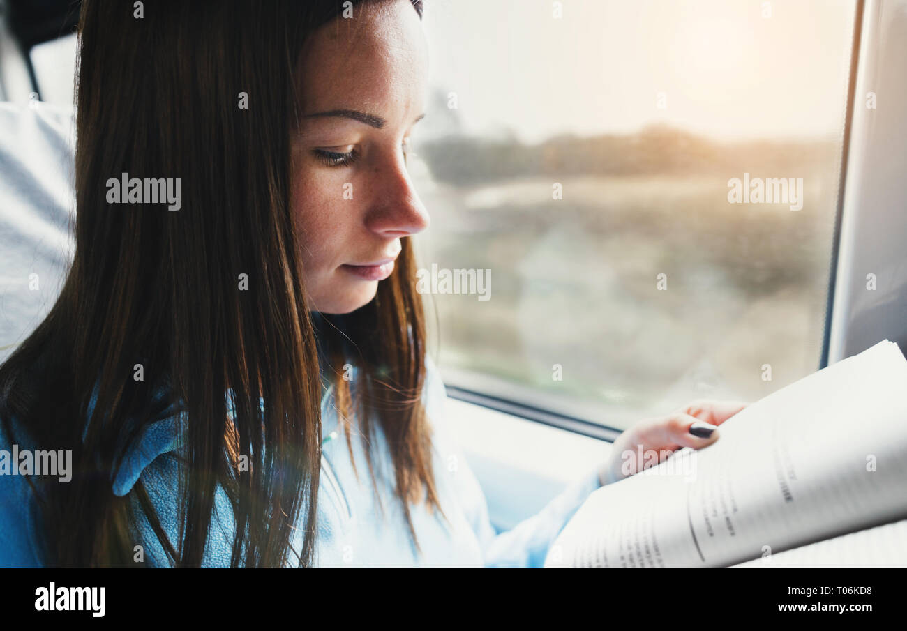 Student girl reading literature in train Stock Photo