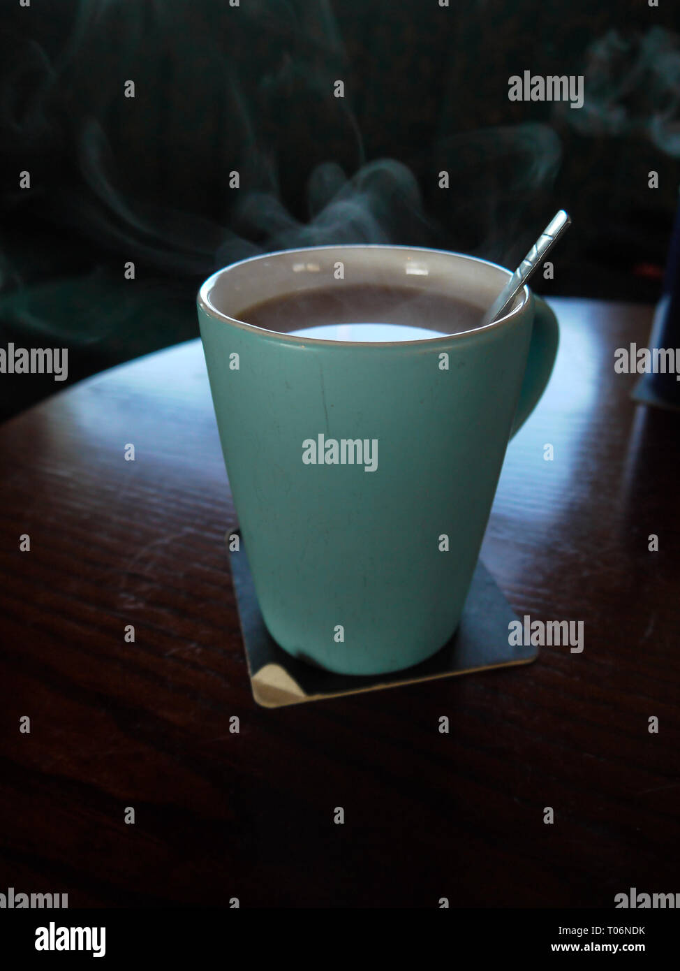 hot tea cup on wood table, Hot drink . with steam,warm soft light, dark  background.Good morning Tea or Have a happy day message concept. Stock  Photo