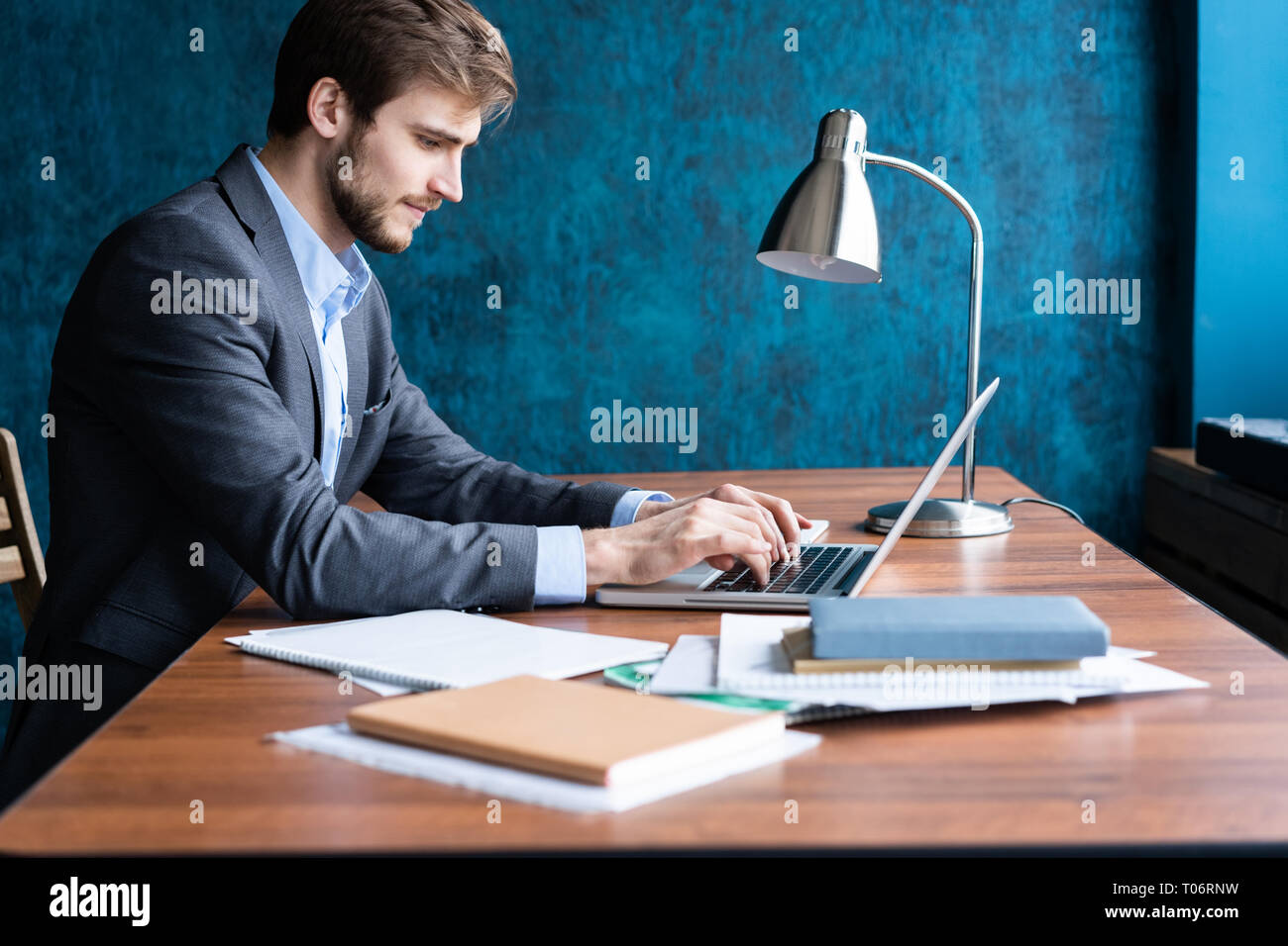 Smiling man in office working on digital tablet. Stock Photo