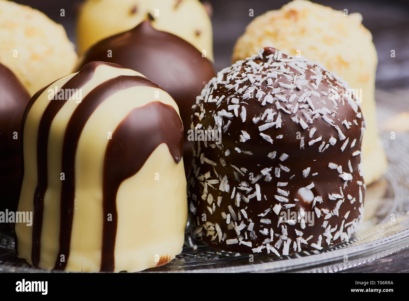 group of white and dark chocolate covered marshmallows on a glass plate, macro color image Stock Photo