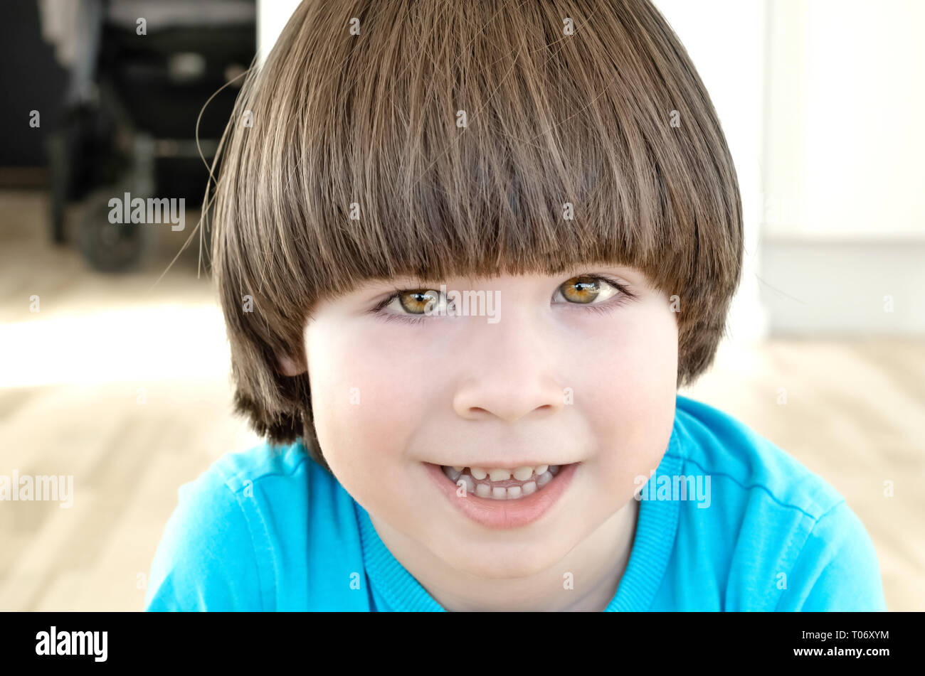 Small boy with long hair is smiling and looking to the camera Stock Photo