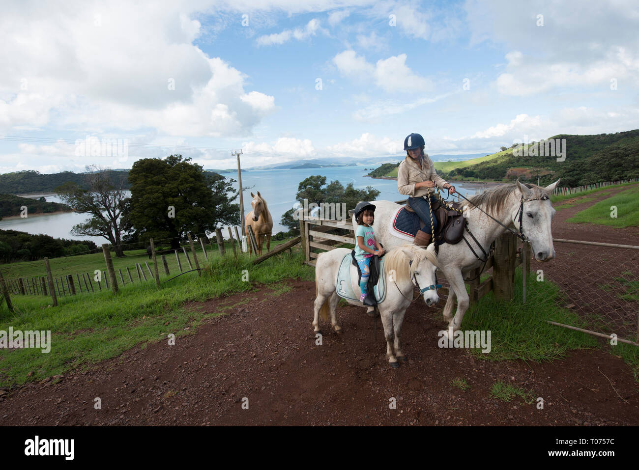 Horseriding, mother and daughter on horse, Equus ferus caballus, Waiheke Island, near Aukland, North Island, New Zealand Stock Photo
