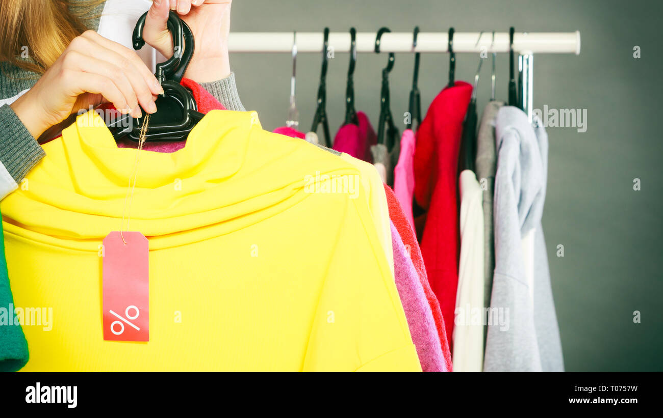 Good shopping sale concept. woman choosing clothes holding discount red  label with percent sign in hand Stock Photo - Alamy