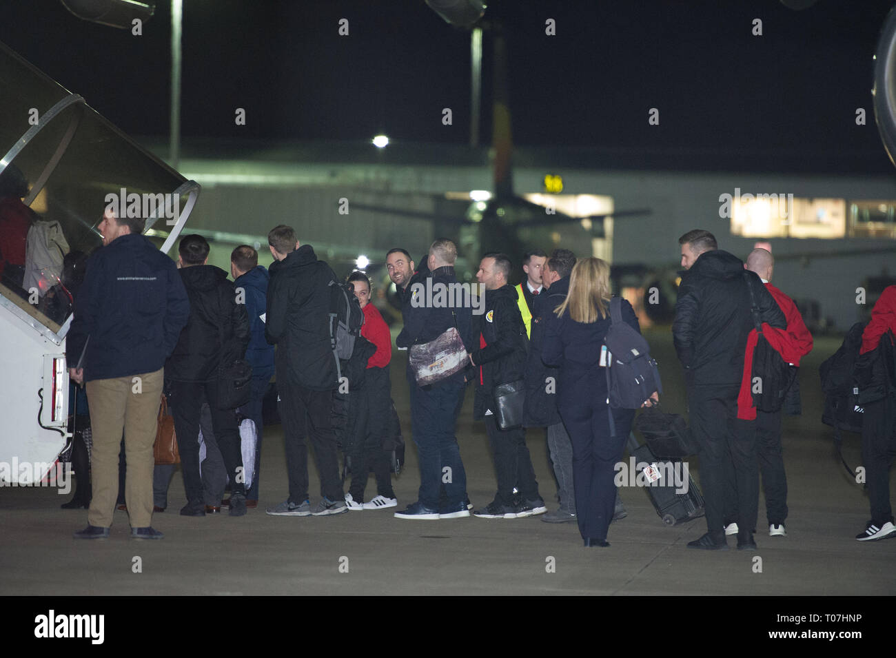 Glasgow, UK. 18 March 2019. Scottish Defender, Callum Patterson (looking at the camera) and the Scotland Football Team seen boarding their luxury jetliner private aircraft in the early hours seen  at Glasgow Airport moments before departing for Kazakhstan to play a game on Wednesday.  The flight was due to take off at 11pm, however due to an unforeseen problem where the pilot had to come out of the flight deck and onto the tarmac and speak with ground crew, the flight eventually took off in the early hours of today. Credit: Colin Fisher/Alamy Live News Stock Photo