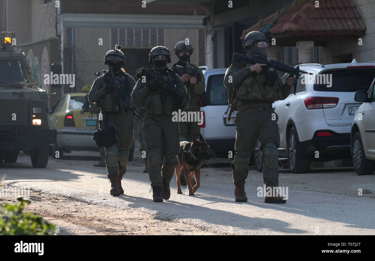 Nablus, West Bank city of Nablus. 18th Mar, 2019. Israeli soldiers patrol a street in Salem village, east of the West Bank city of Nablus, March 18, 2019. Israeli troops searched the West Bank for the suspected Palestinian killer of an Israeli soldier on Monday. The Palestinian killed an Israeli and severely injured two others in shooting and stabbing attacks before fleeing the scene on Sunday, Israeli army said. Credit: Nidal Eshtayeh/Xinhua/Alamy Live News Stock Photo