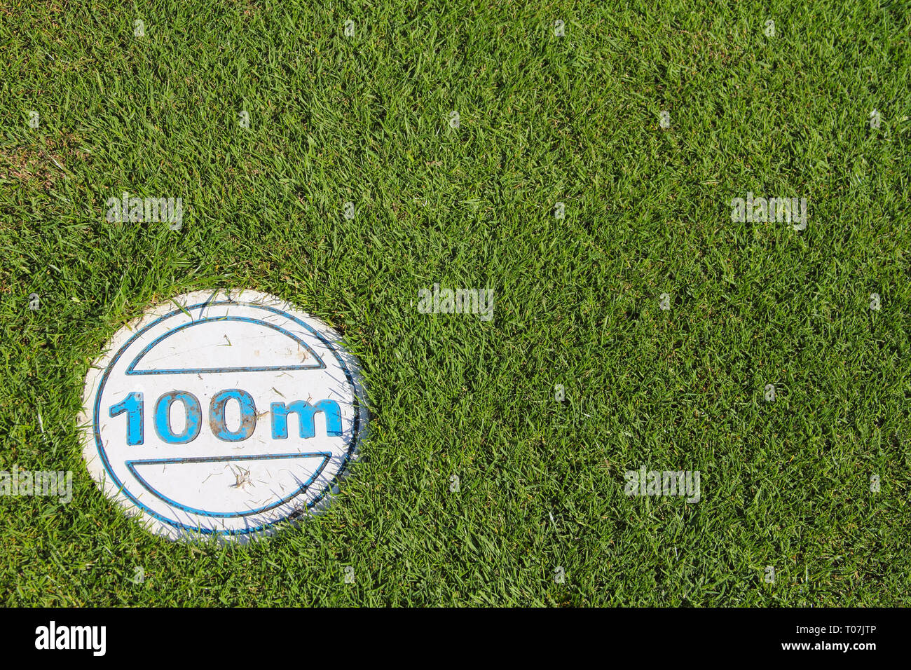 Golf Course green grass textured background with 100 m mark Stock Photo